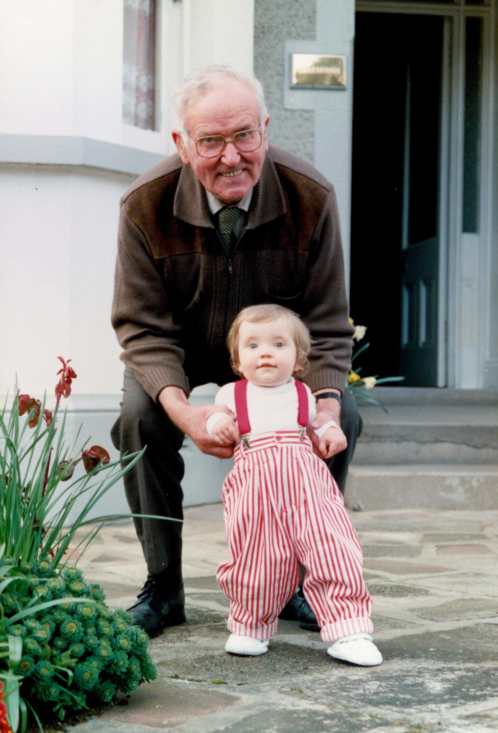 Dad, enjoying time with his granddaughter; my eldest daughter, Chloe, now married with two children of her own.